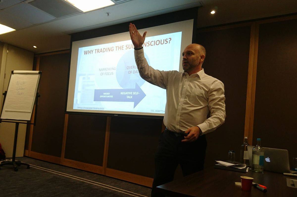 a man holds his head while sitting on a sofa
